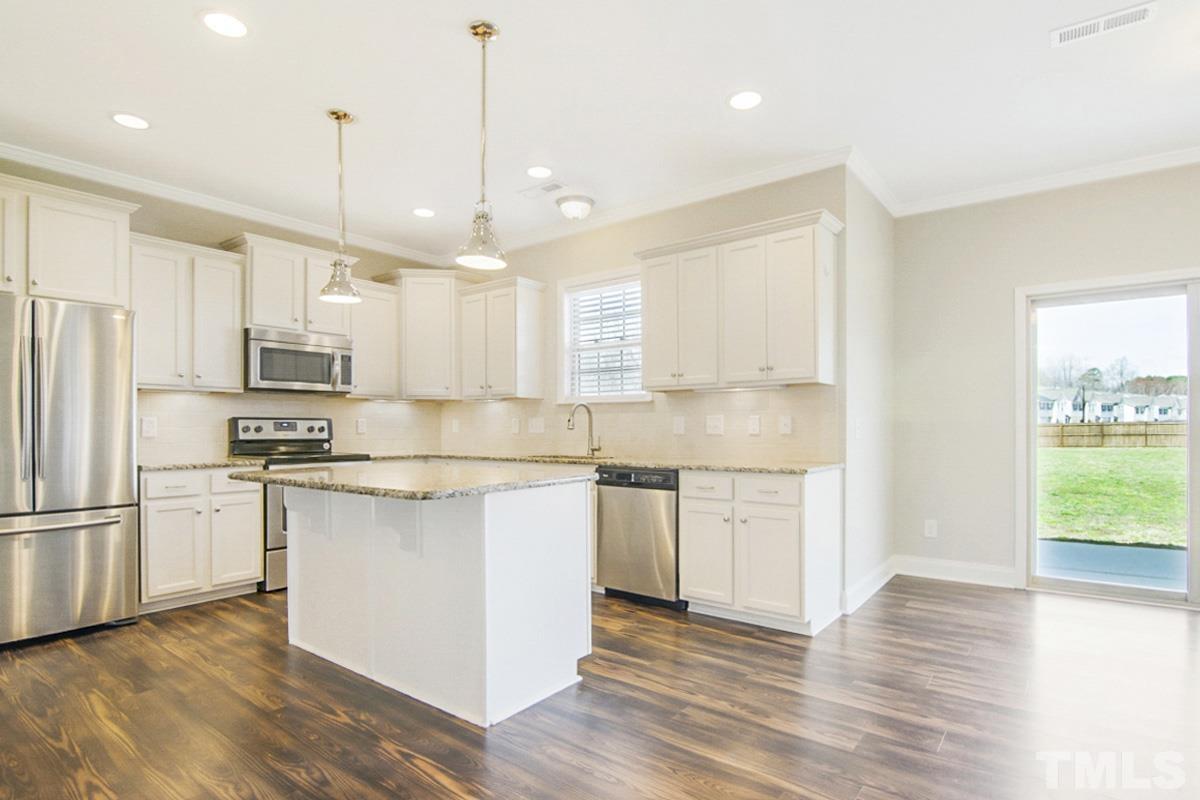 35 Waterpine Drive Garner, NC 27529 - Photo 4 of 25 a kitchen with stainless steel appliances granite countertop a refrigerator a sink dishwasher a stove and white countertops with wooden floor