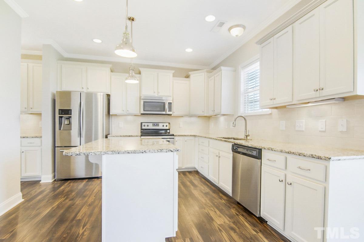 35 Waterpine Drive Garner, NC 27529 - Photo 5 of 25 a kitchen with stainless steel appliances granite countertop a refrigerator sink and white cabinets
