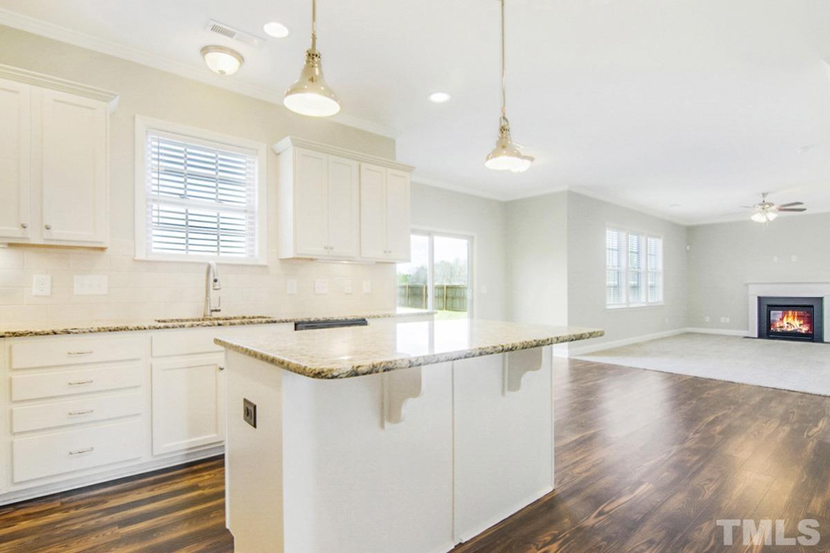 35 Waterpine Drive Garner, NC 27529 - Photo 6 of 25 a kitchen with stainless steel appliances granite countertop a sink a stove and white cabinets with wooden floor