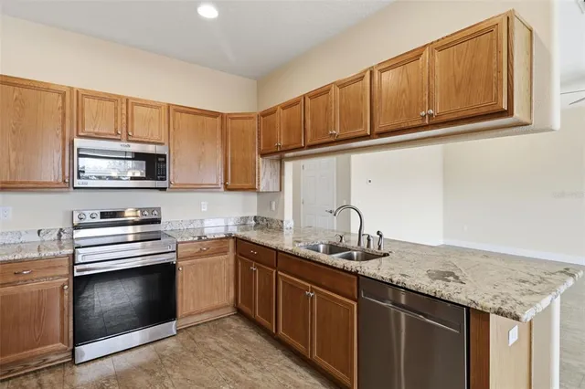 a kitchen with stainless steel appliances granite countertop a sink stove and microwave