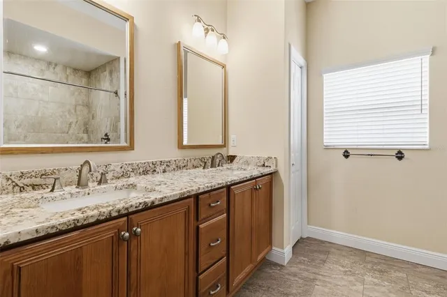 a bathroom with a granite countertop sink and a mirror