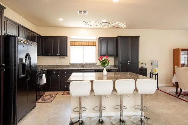 a kitchen with stainless steel appliances kitchen island granite countertop a refrigerator and a stove top oven