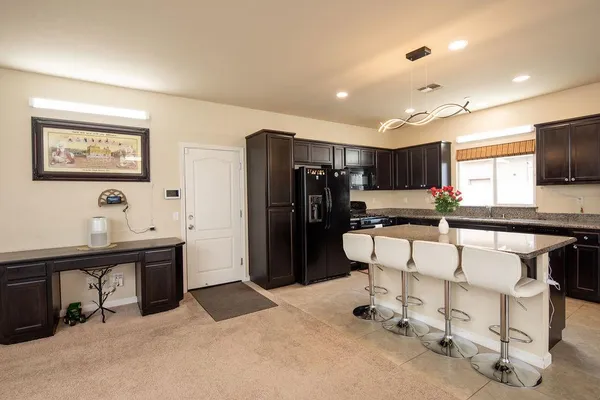 a living room with stainless steel appliances kitchen island furniture and a window