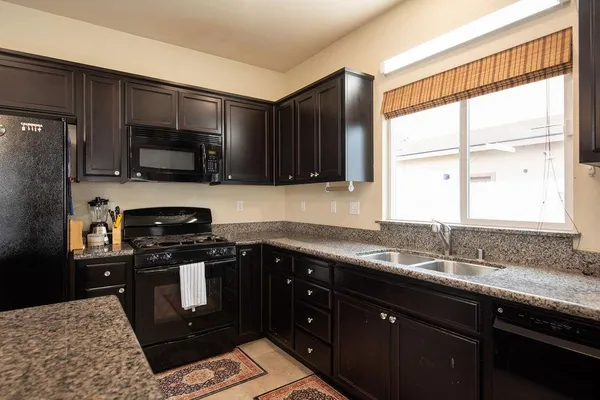 a kitchen with stainless steel appliances granite countertop a sink stove and microwave