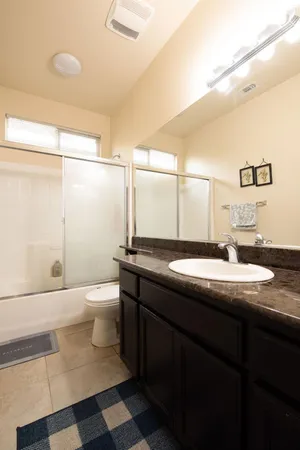 a bathroom with a granite countertop sink toilet and shower