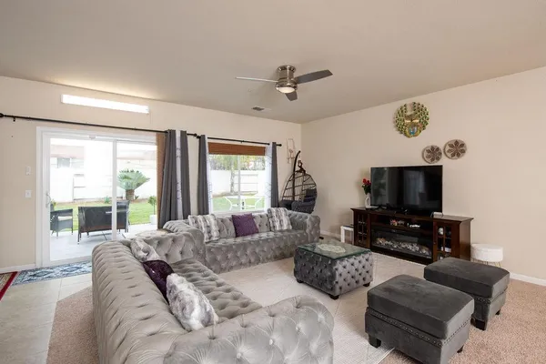 a living room with furniture flat screen tv and a large window