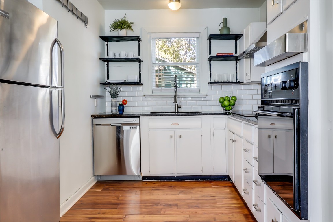 1105 West 43rd Street Austin, TX 78756 - Photo 7 of 22 a kitchen with stainless steel appliances a sink and a refrigerator