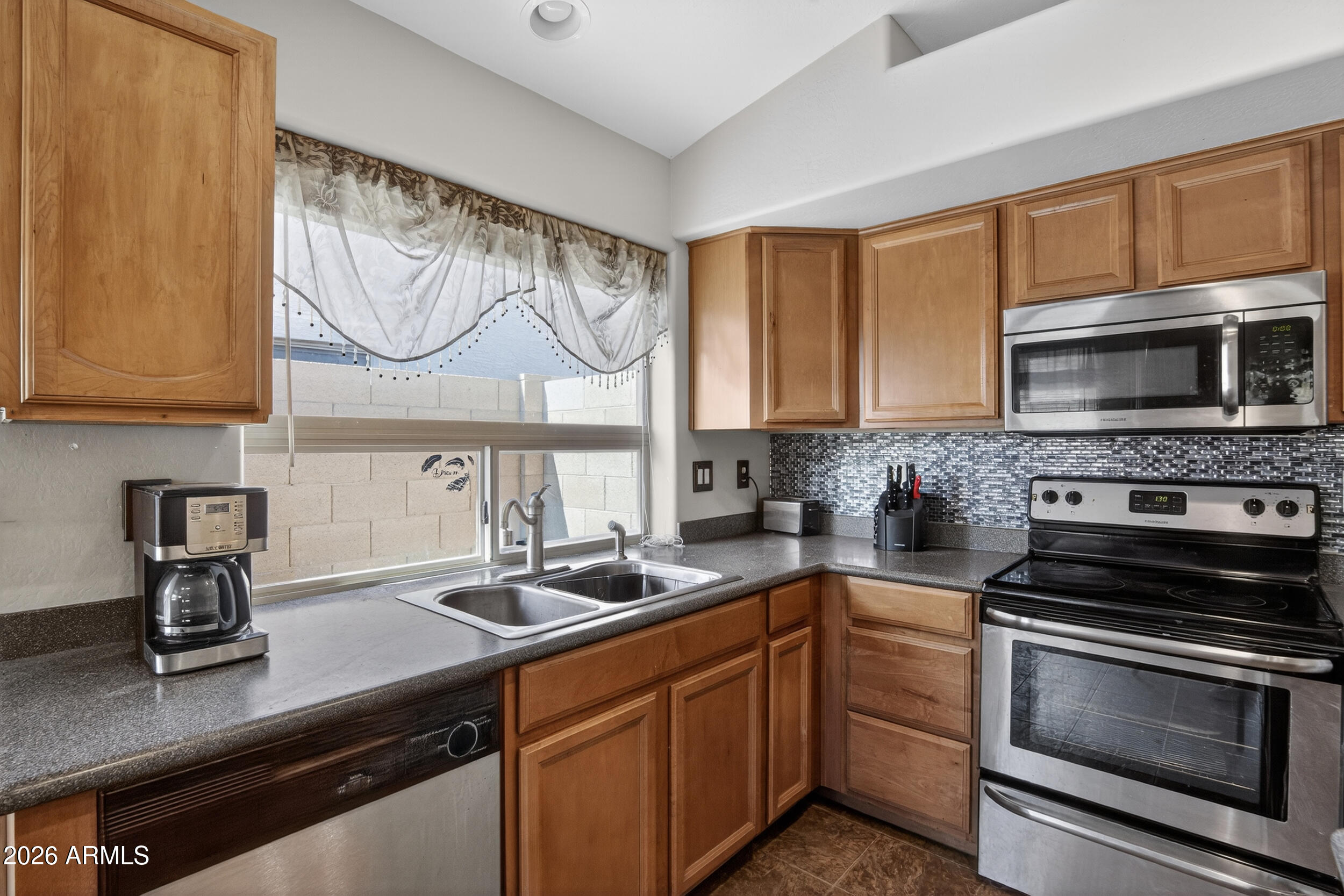 515 West Love Road San Tan Valley, AZ 85143 - Photo 9 of 74 a kitchen with stainless steel appliances granite countertop a sink and a stove