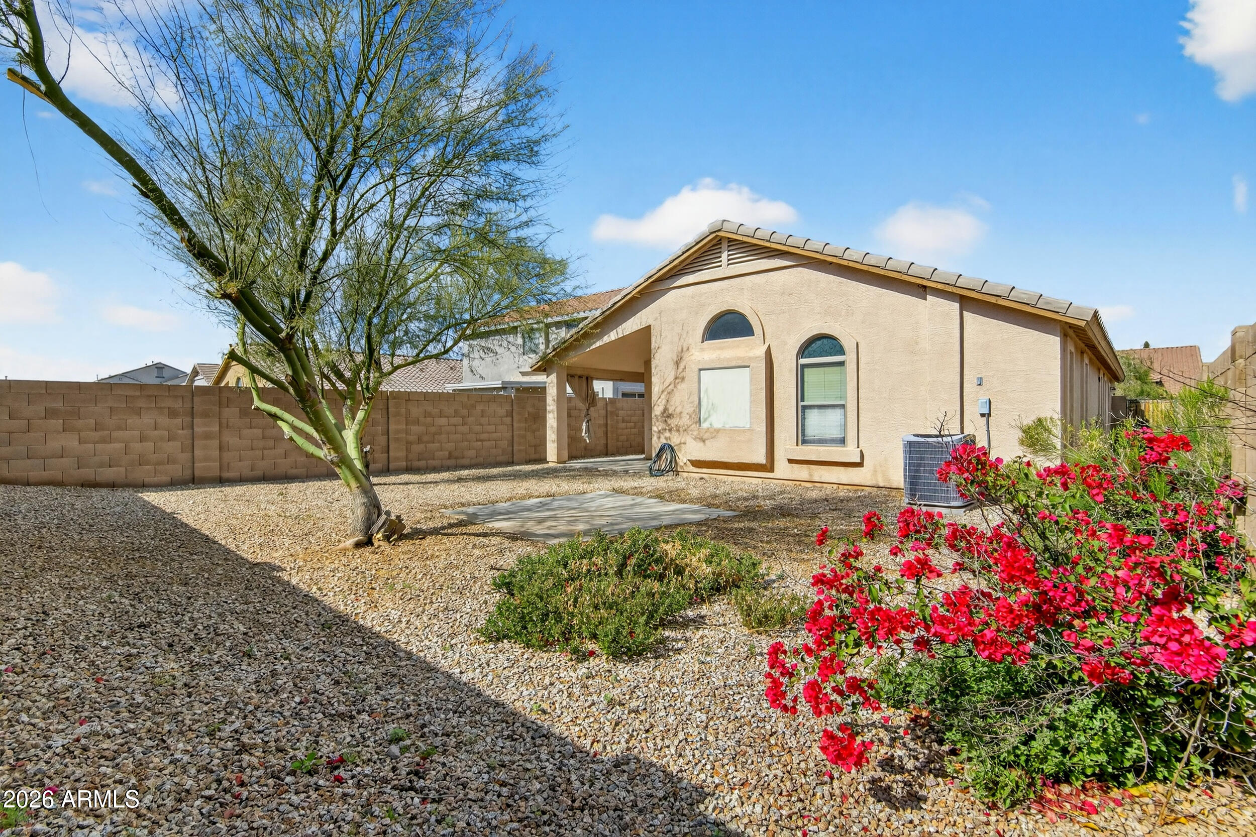 515 West Love Road San Tan Valley, AZ 85143 - Photo 30 of 74 a white house with a flower garden in front of it