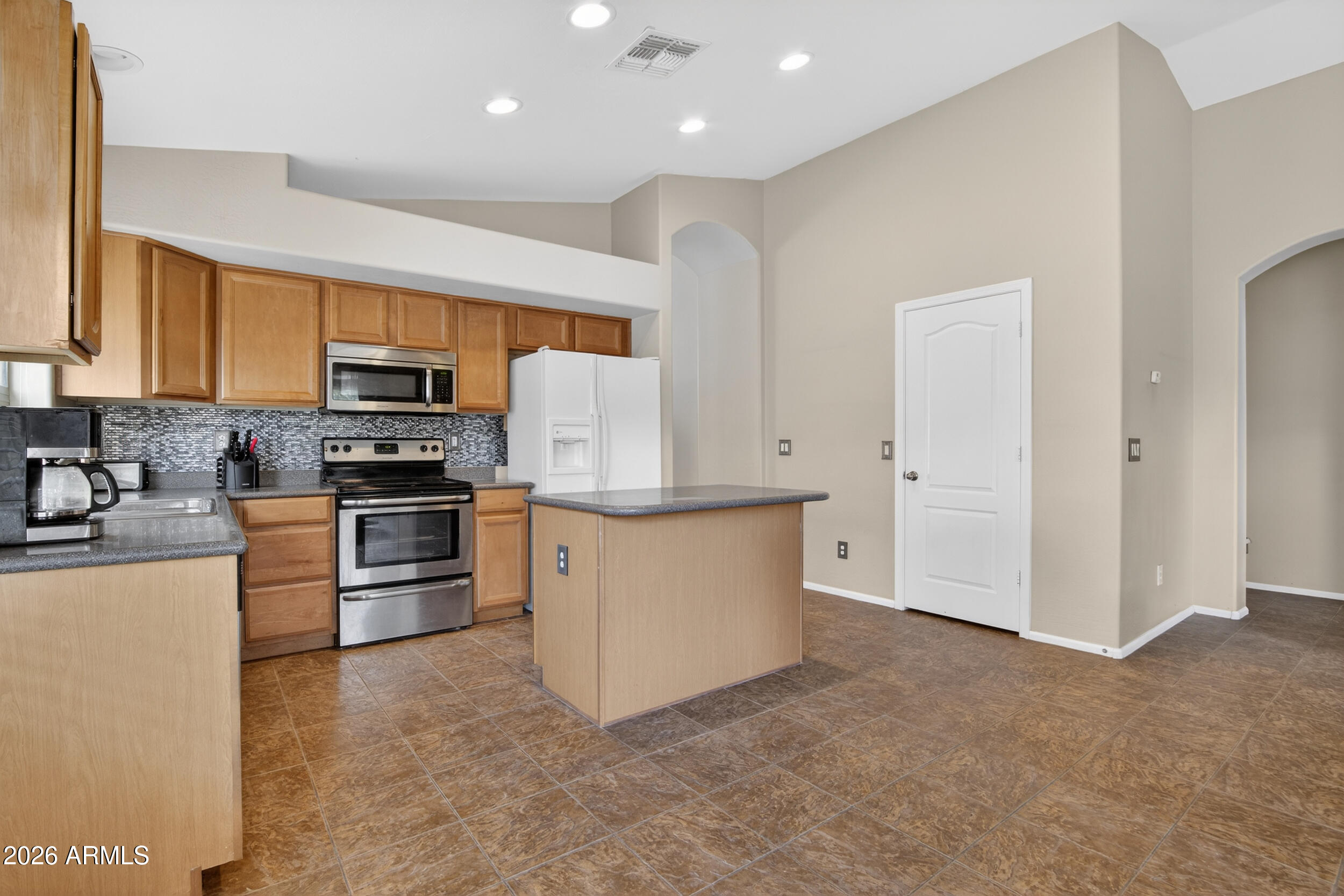 515 West Love Road San Tan Valley, AZ 85143 - Photo 7 of 74 a kitchen with granite countertop white cabinets and stainless steel appliances