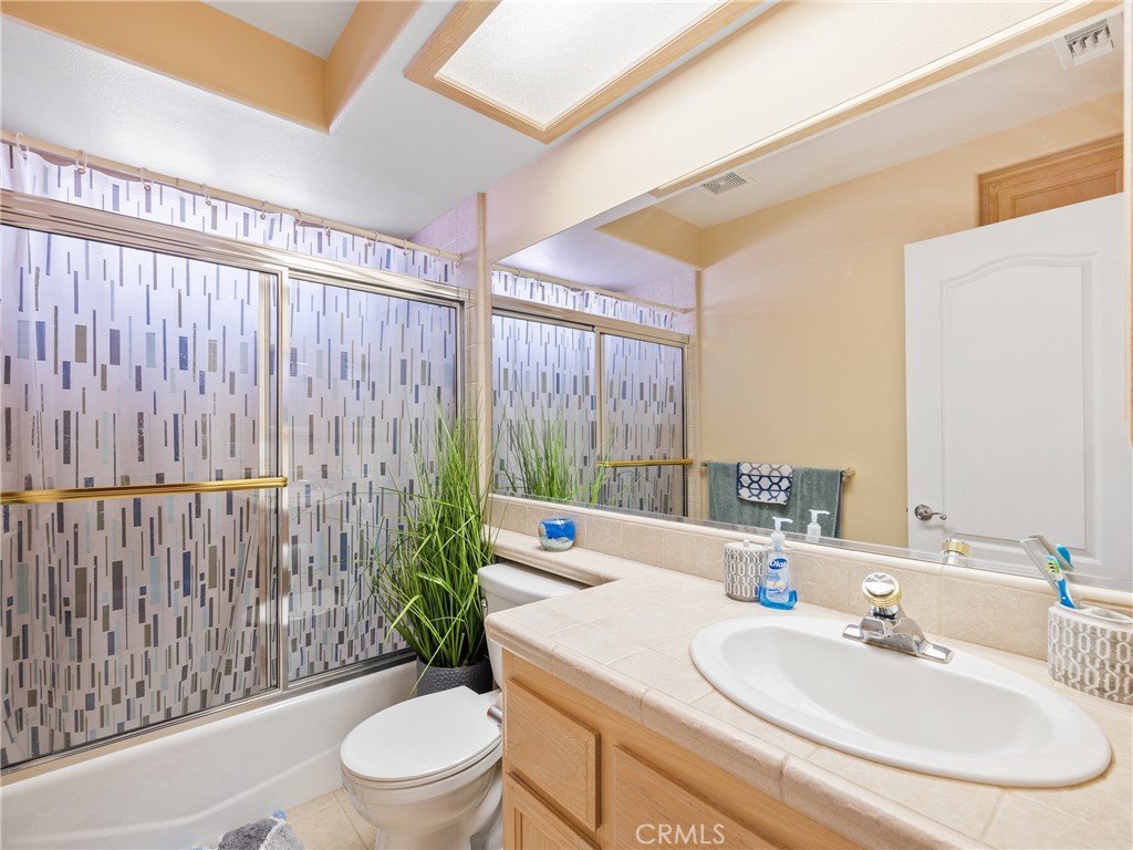 39429 Mountain View Road Yermo, CA 92398 - Photo 42 of 47 a bathroom with a sink a toilet a mirror and shower curtain