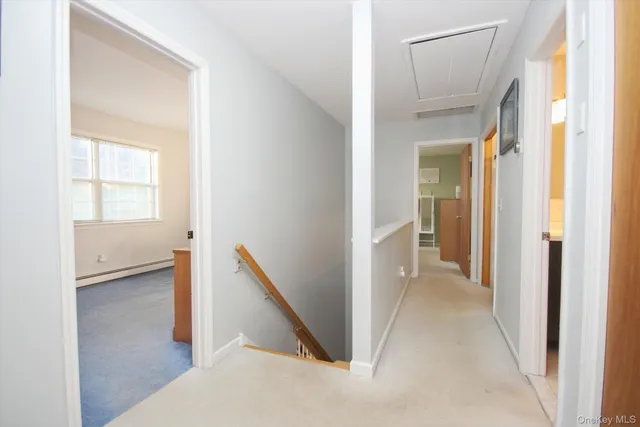 a view of a hallway with wooden floor and a living room