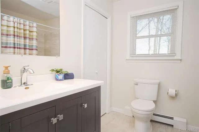 a bathroom with a sink a toilet and a window