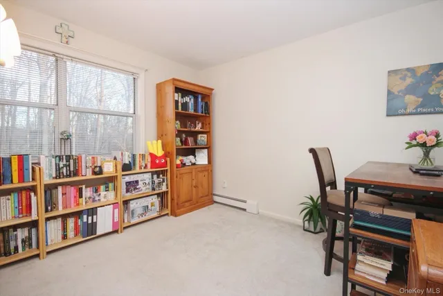 a view of a workspace with furniture and a book shelf