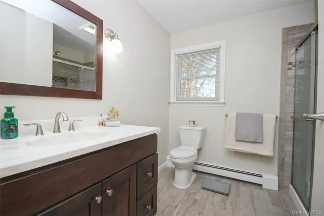 a bathroom with a toilet sink a mirror and vanity