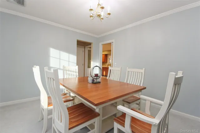 a view of a dining room with furniture and chandelier