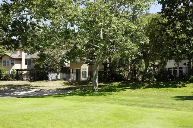 a view of a swimming pool with lawn chairs and plants