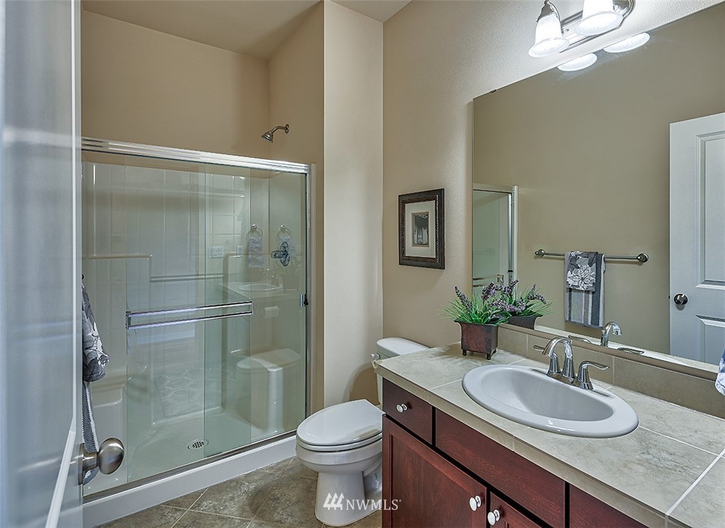 4201 222nd Place Southeast Bothell, WA 98021 - Photo 13 of 25 a bathroom with a granite countertop sink toilet a mirror and shower