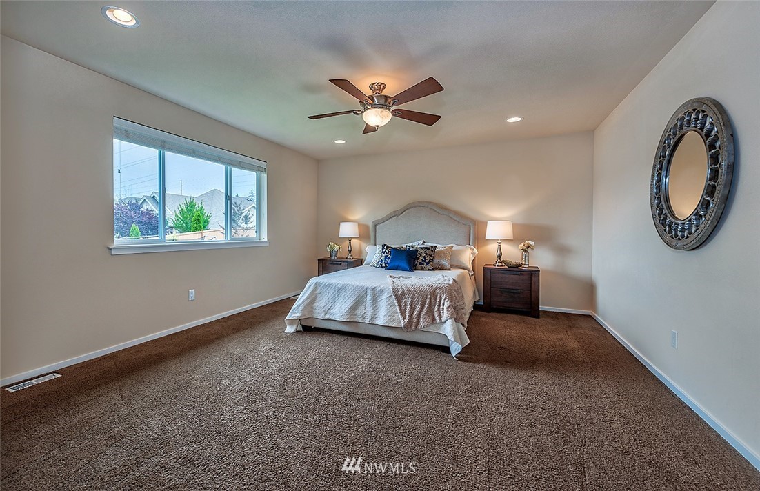 4201 222nd Place Southeast Bothell, WA 98021 - Photo 15 of 25 a spacious bedroom with a bed and a chandelier