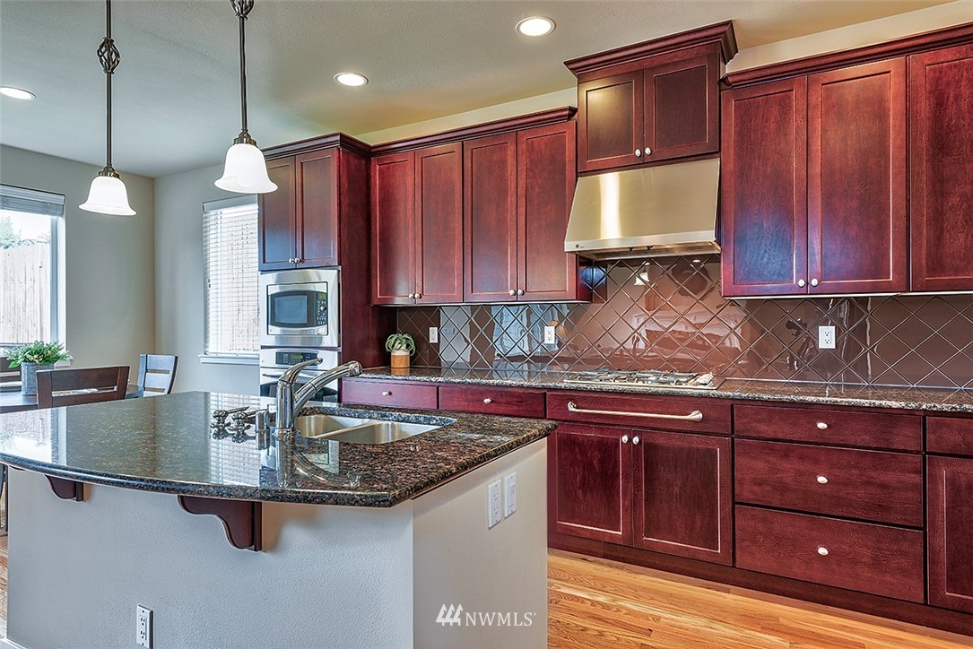 4201 222nd Place Southeast Bothell, WA 98021 - Photo 5 of 25 a kitchen with kitchen island granite countertop a sink a counter top space and cabinets