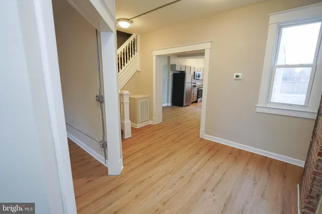 a view of a hallway with wooden floor and staircase