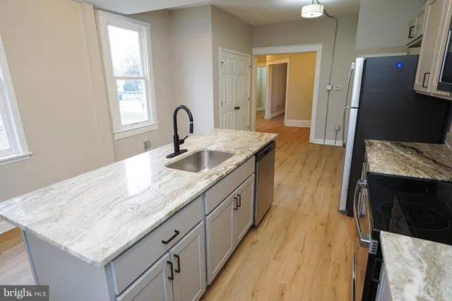 a hallway with sink and mirror