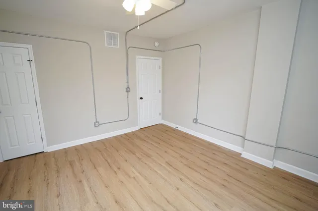 a view of an empty room with wooden floor