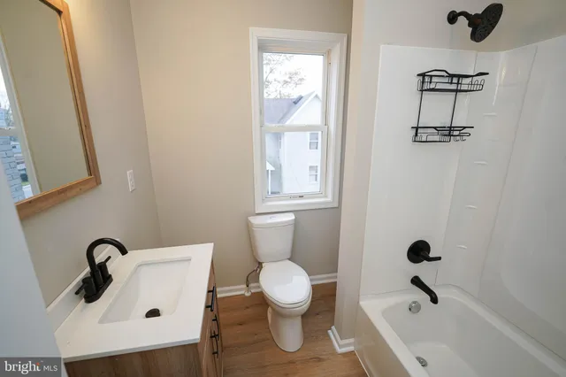 a bathroom with a toilet a sink and mirror