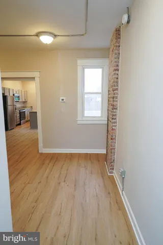 a view of a room with wooden floor and a window