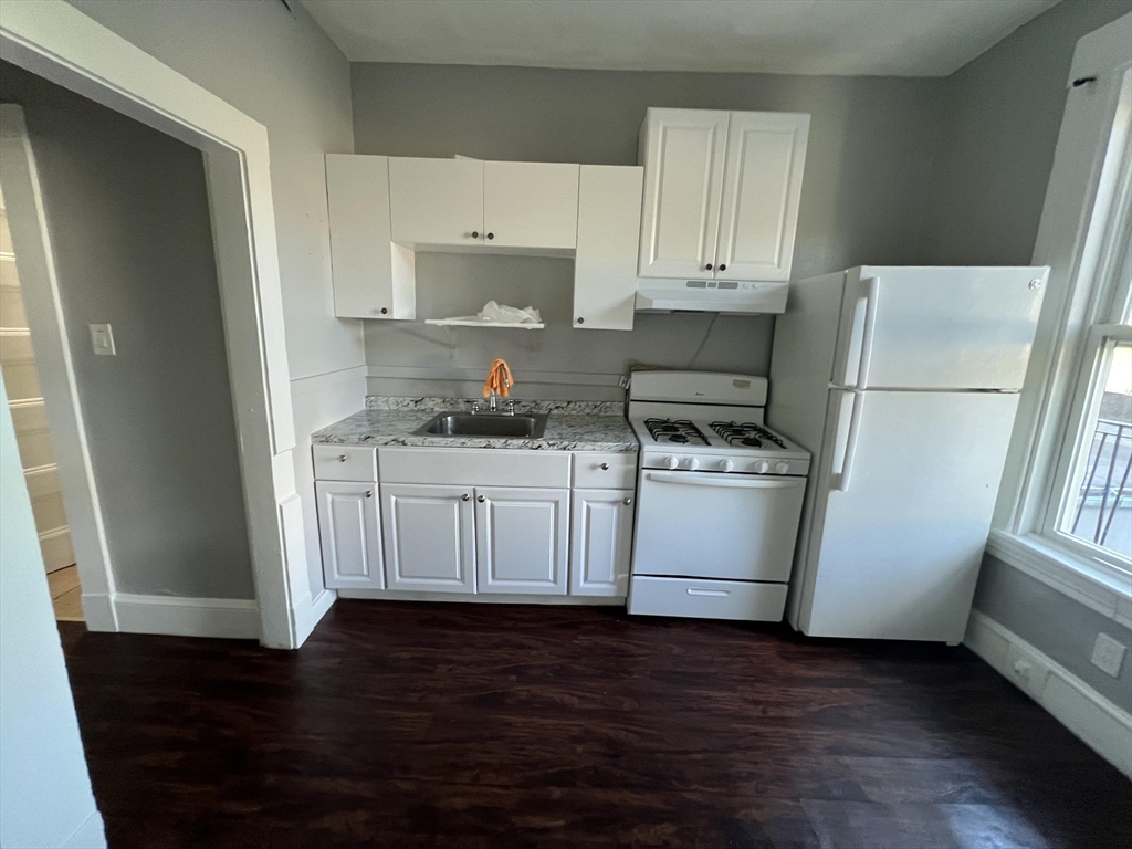 64 Hollis Street, Unit 16 Framingham, MA 01702 - Photo 2 of 6 a kitchen with white cabinets and white appliances