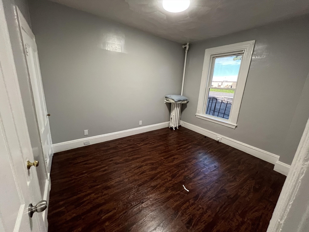 64 Hollis Street, Unit 16 Framingham, MA 01702 - Photo 5 of 6 an empty room with wooden floor and windows