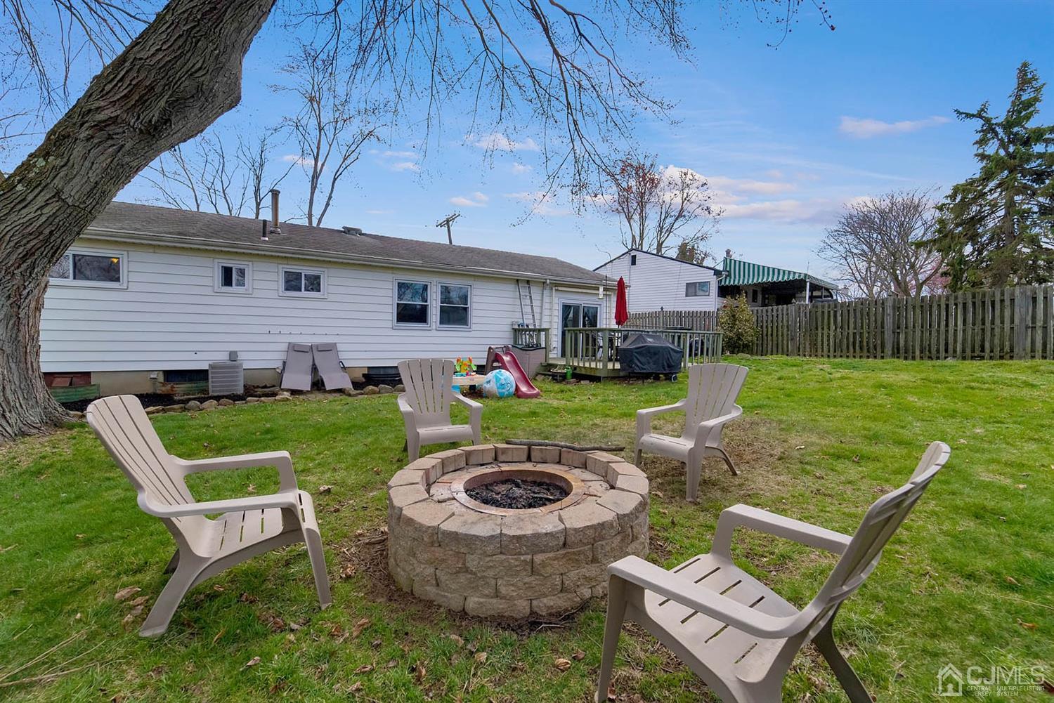 21 Villanova Road Old Bridge, NJ 08859 - Photo 14 of 15 a view of a backyard with table and chairs with a fire pit and potted plants