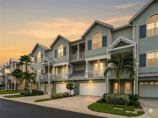 a view of a house with large windows and a small yard