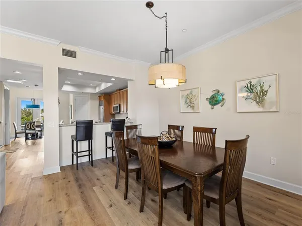a kitchen with stainless steel appliances granite countertop a stove top oven a refrigerator a sink and dishwasher with wooden floor