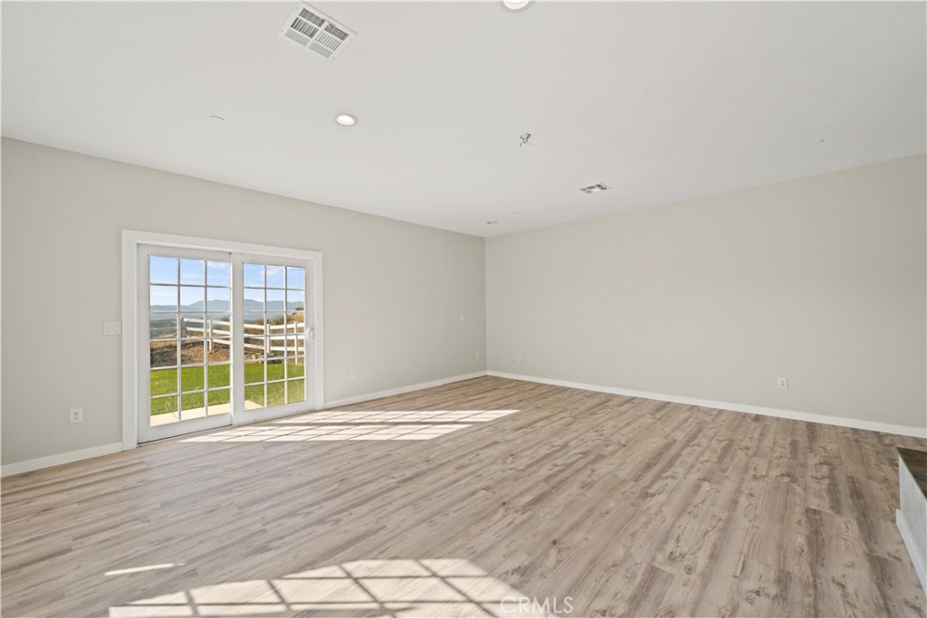 13560 Sego Road Agua Dulce, CA 91390 - Photo 20 of 75 a view of an empty room with wooden floor and a window