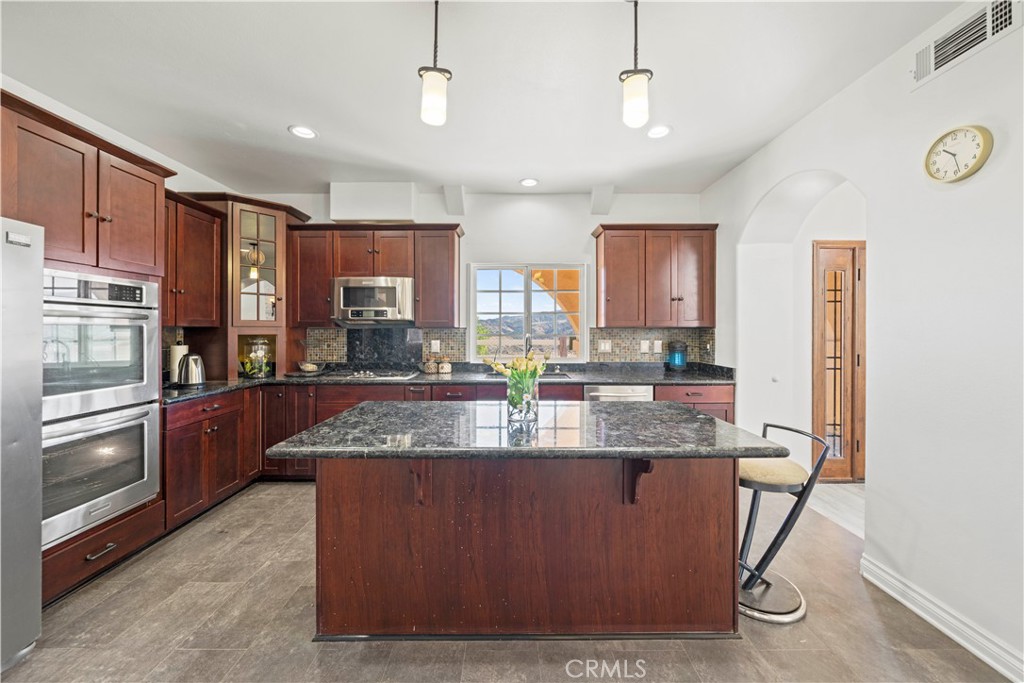 13560 Sego Road Agua Dulce, CA 91390 - Photo 25 of 75 a kitchen with stainless steel appliances granite countertop a stove refrigerator and cabinets