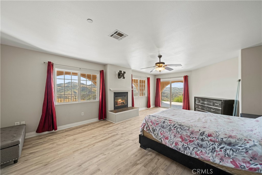 13560 Sego Road Agua Dulce, CA 91390 - Photo 27 of 75 a spacious bedroom with a large bed large window with wooden floor