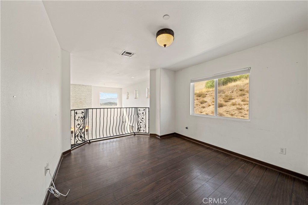 13560 Sego Road Agua Dulce, CA 91390 - Photo 39 of 75 an empty room with wooden floor and windows