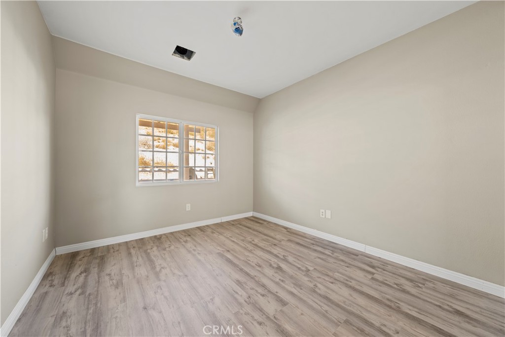 13560 Sego Road Agua Dulce, CA 91390 - Photo 45 of 75 an empty room with wooden floor and windows