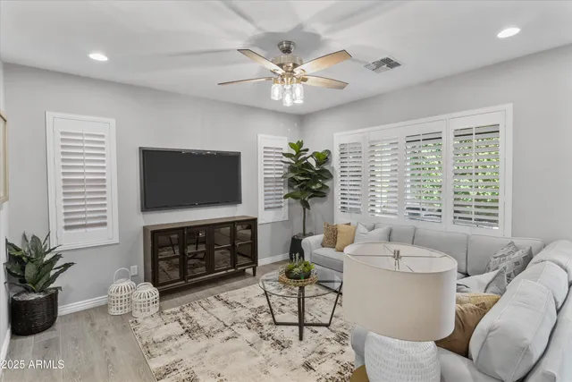 a living room with furniture a flat screen tv and a large window