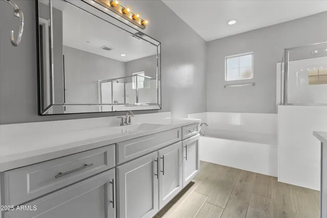 a bathroom with a sink a large mirror and a bathtub