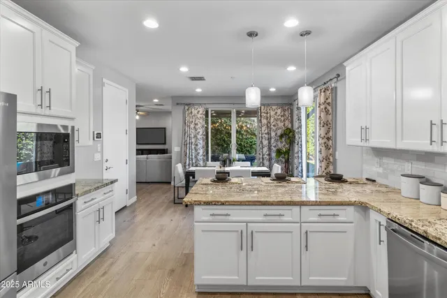 a kitchen with a sink stainless steel appliances and white cabinets