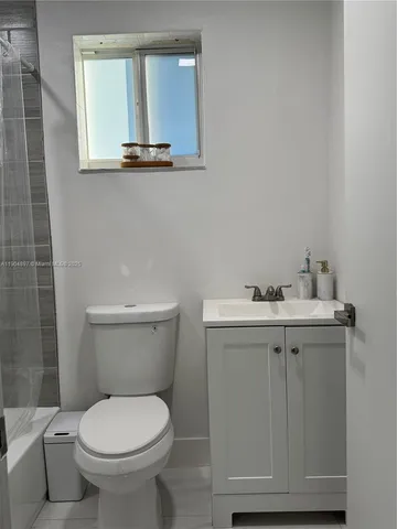 a white toilet sitting next to a bath tub