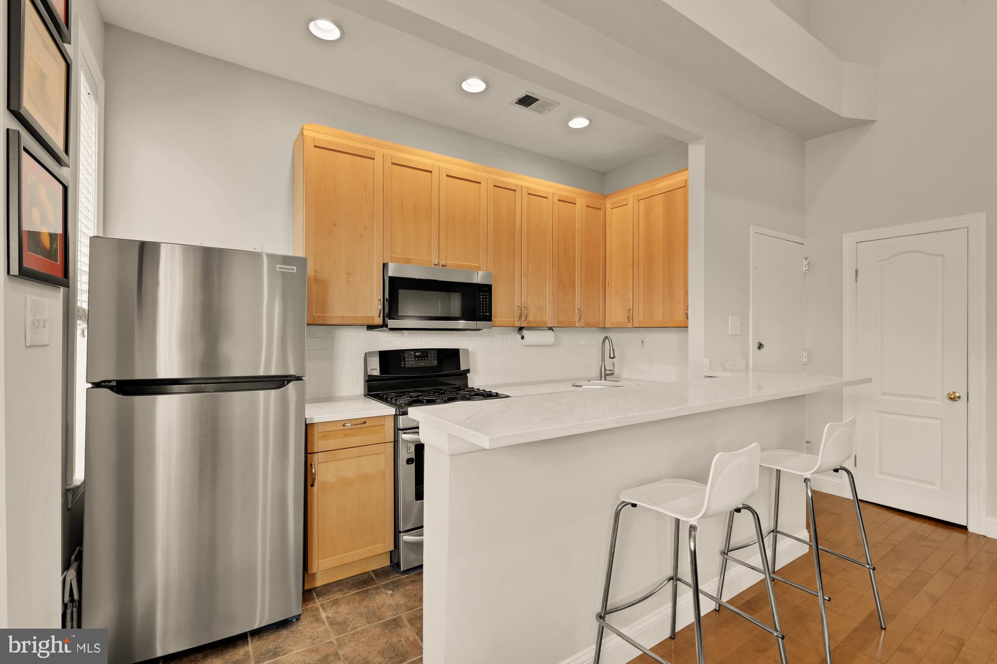 1933 18th Street Northwest, Unit 304 Washington, DC 20009 - Photo 8 of 24 a kitchen with stainless steel appliances a refrigerator sink and white cabinets