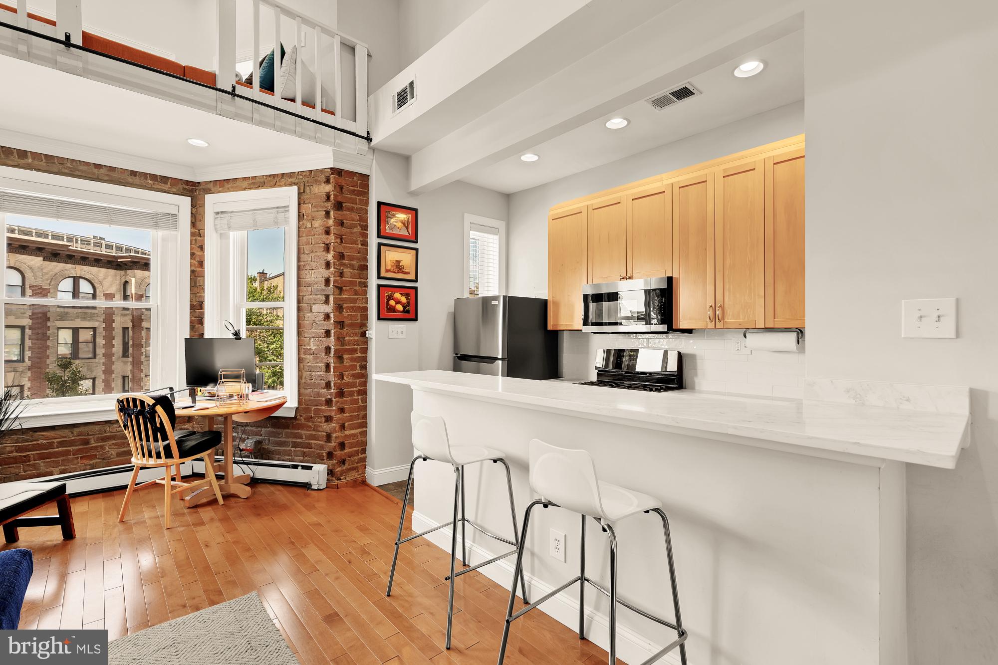 1933 18th Street Northwest, Unit 304 Washington, DC 20009 - Photo 9 of 24 a kitchen with stainless steel appliances a stove a sink a oven a dining table and chairs with wooden floor