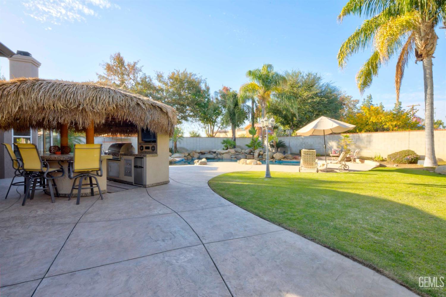 Undisclosed Address Bakersfield, CA 93312 - Photo 21 of 33 a view of a patio with a table and chairs under an umbrella