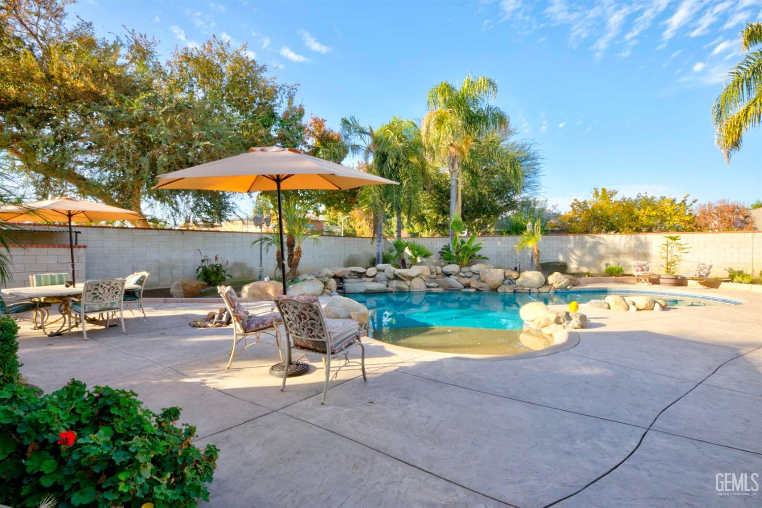 Undisclosed Address Bakersfield, CA 93312 - Photo 22 of 33 a view of a patio with a table and chairs under an umbrella