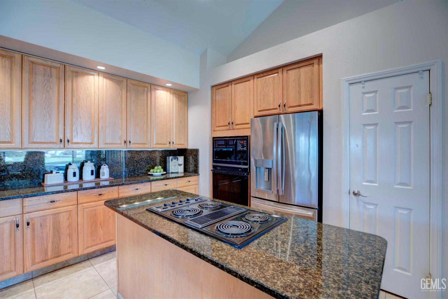 Undisclosed Address Bakersfield, CA 93312 - Photo 9 of 33 a kitchen with kitchen island granite countertop a sink stove and refrigerator