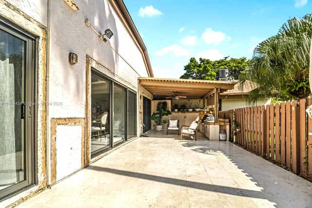 a view of a patio with table and chairs with wooden fence