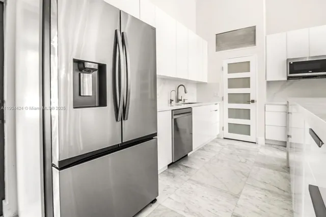 a kitchen with stainless steel appliances a refrigerator sink and cabinets